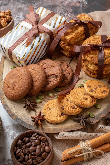 Vorderansicht süße Kekse mit Nüssen und Geschenken auf heller Hintergrundfarbe Zuckerteekuchen süßes Tortengebäck