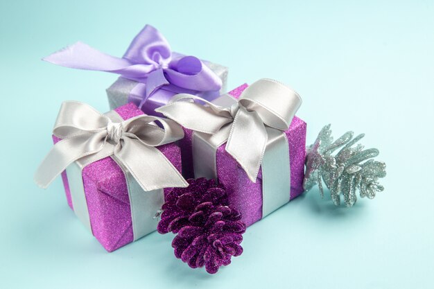Vorderansicht süße kleine Geschenke auf dem hellblauen Tisch