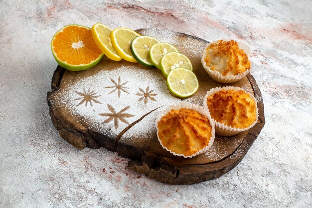 Vorderansicht süße Kuchen mit Zitronenscheiben auf dem weißen Schreibtischkeks süß backen Kuchen Zuckerkuchenplätzchen