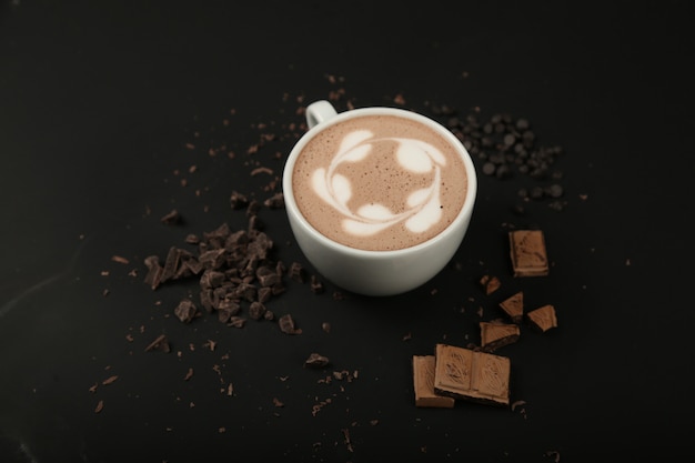 Vorderansicht Tasse Cappuccino mit Schokolade auf schwarzer Oberfläche