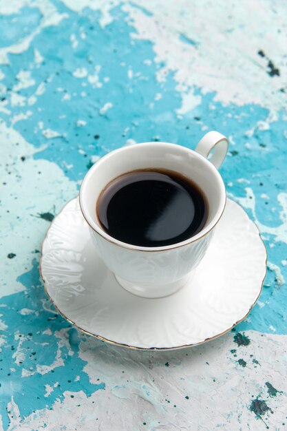 Vorderansicht Tasse Kaffee heißes und starkes Getränk auf hellblauer Oberfläche trinken Kaffee Kakao schlafen Farbfoto