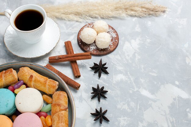 Vorderansicht Tasse Tee mit Bagels und Macarons auf Weiß