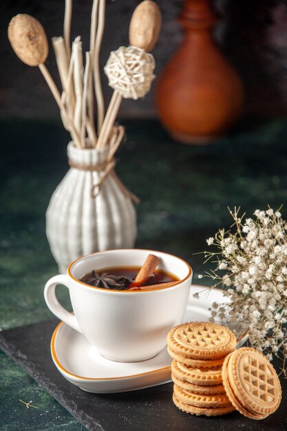 Vorderansicht Tasse Tee mit süßen Keksen auf dunkler Oberfläche Brot trinken Zeremonie Glas süßen Kuchen Farbfoto Zucker Morgen