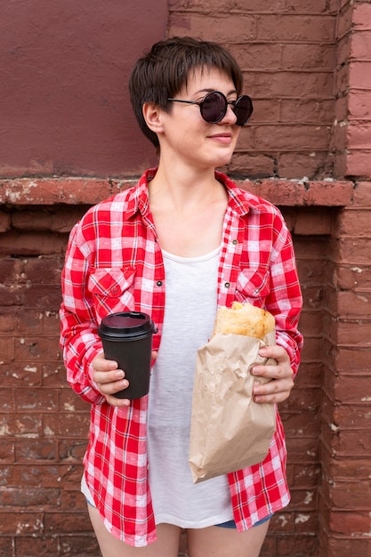 Vorderansicht-Teenager, der Essen und Kaffee hält