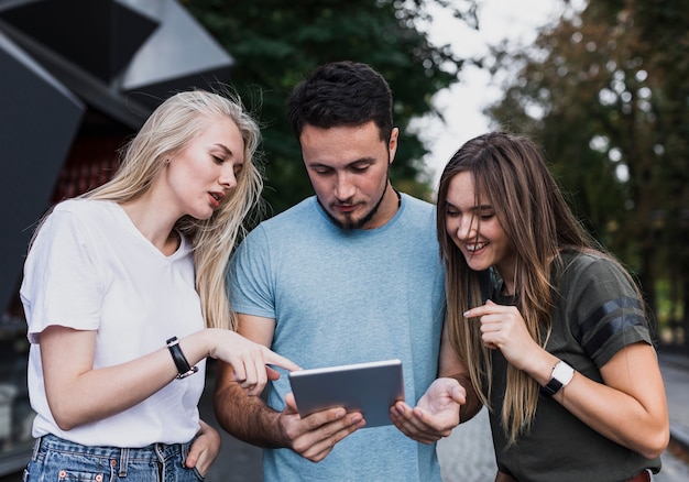 Kostenloses Foto vorderansicht-teenager, der in einer tablette schaut