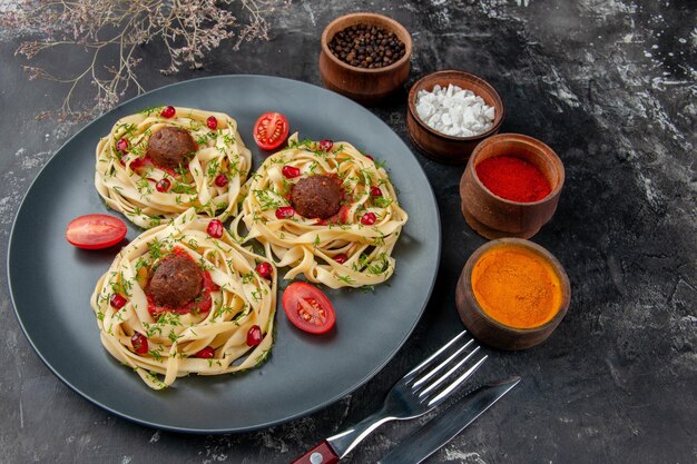 Vorderansicht Teigscheiben mit Fleischbällchen und Gewürzen auf hellgrauer Hintergrundfarbe Fleischrestaurant Abendessen Kochgericht Pasta