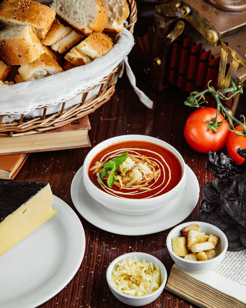 Vorderansicht Tomatensuppe mit Crackern und Käsetomaten und Brot auf dem Tisch