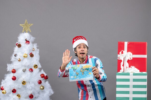 Vorderansicht überraschte Mann mit Spiralfeder-Weihnachtsmütze, die hohes fünf Zeichen macht