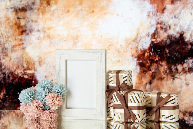 Vorderansicht valentinstag geschenke gebunden mit bandblumen weißer fotorahmen reflektiert auf spiegel auf abstraktem hintergrund