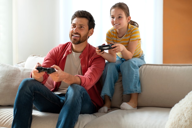 Vorderansicht: Vater und Mädchen spielen Videospiel