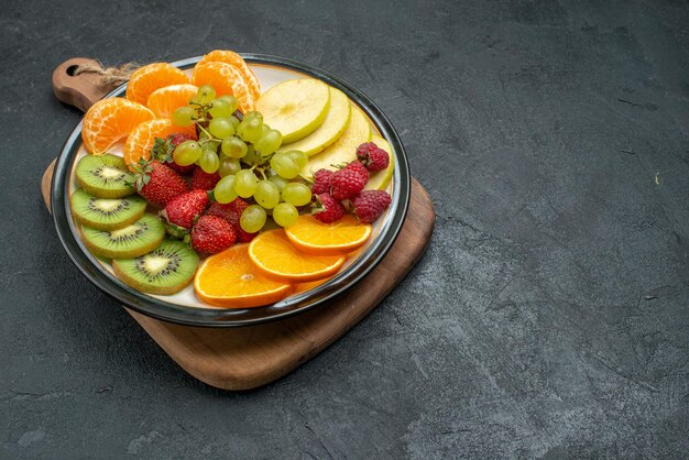 Vorderansicht verschiedene Fruchtzusammensetzung frisch geschnitten und reif auf dem grauen Hintergrund ausgereifte frische Früchte Gesundheit reif