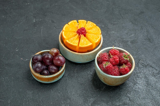 Vorderansicht verschiedene Fruchtzusammensetzung frisches ausgereiftes und geschnittenes Obst auf dunklem Hintergrund frisches Obst ausgereifte Gesundheit reif