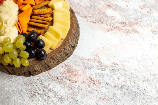 Kostenloses Foto vorderansicht verschiedene snacks cips würstchen käse und frische trauben auf leerraum