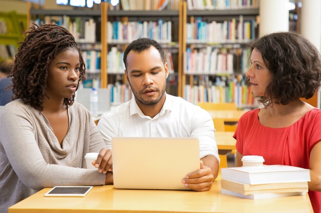 Vorderansicht von den durchdachten Leuten, die an der Bibliothek arbeiten