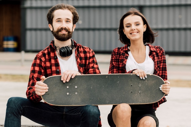 Vorderansicht von den Paaren, die Skateboard halten