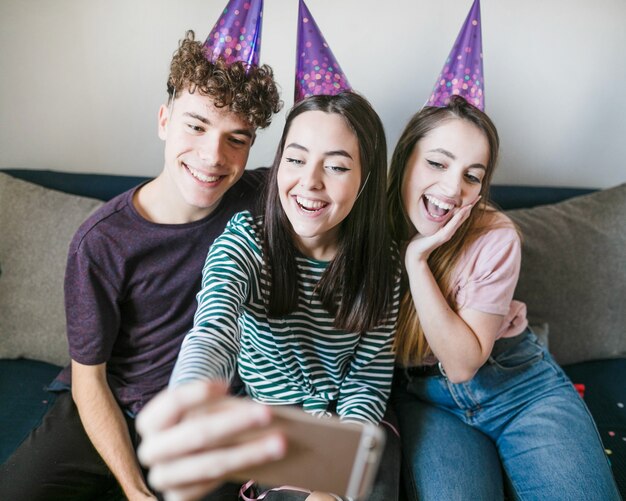 Vorderansicht von den smileyfreunden, die für ein selfie aufwerfen