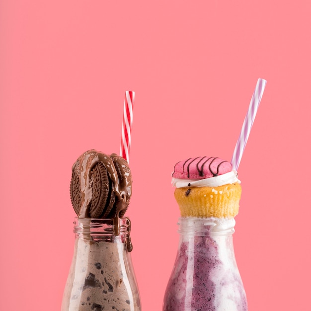 Vorderansicht von Desserts mit Keks und Muffins mit Strohhalmen