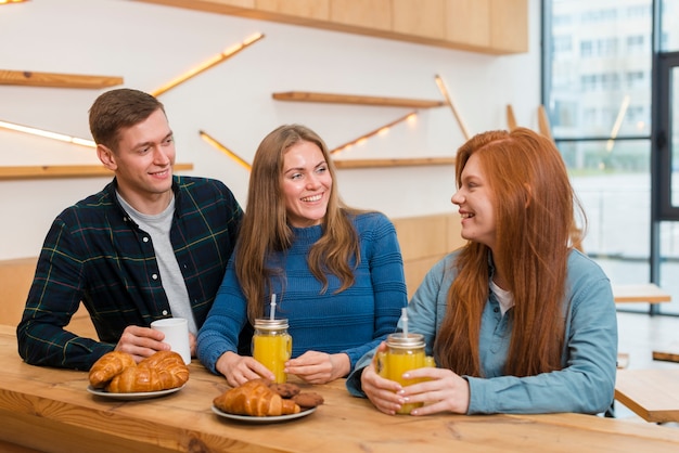 Vorderansicht von Freunden, die am Tisch sprechen