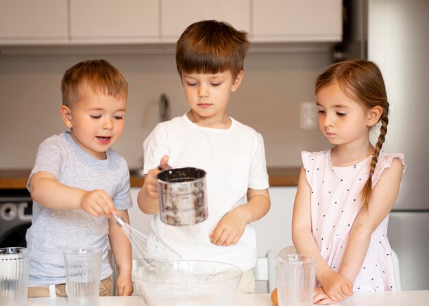 Vorderansicht von Geschwistern, die zu Hause kochen