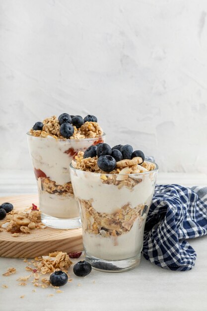 Vorderansicht von Gläsern mit Frühstücksflocken und Joghurt