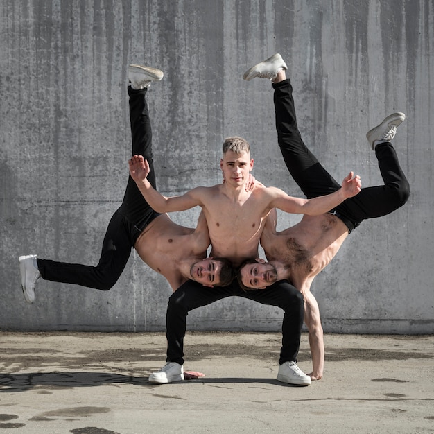 Kostenloses Foto vorderansicht von hemdlosen hip-hop-darstellern, die tanzhaltung üben