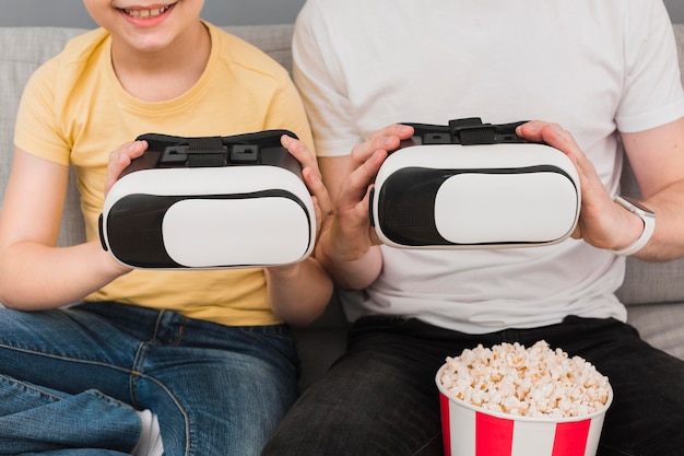 Kostenloses Foto vorderansicht von jungen und mann, die virtual-reality-headset mit popcorn halten