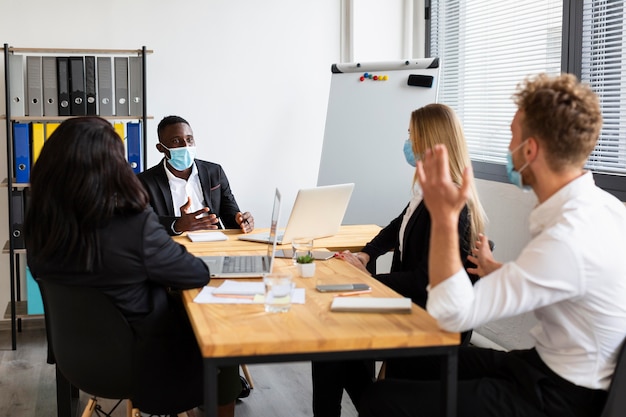 Vorderansicht von Kollegen, die während covid arbeiten