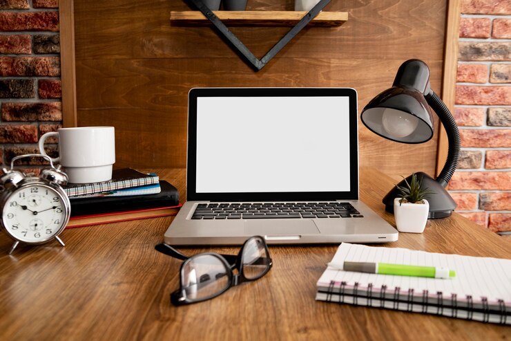 Kostenlose Foto vorderansicht von laptop und lampe auf hölzernem büroarbeitsplatz