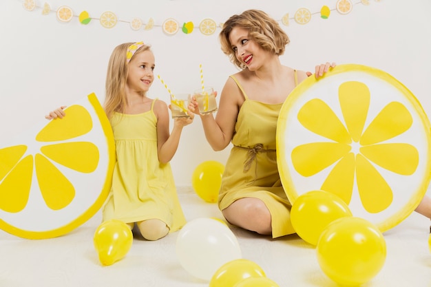 Vorderansicht von Mädchen und Frau, die mit Limonade rösten