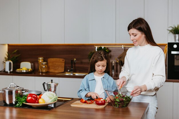 Vorderansicht von Mutter und Tochter, die Essen in der Küche zubereiten