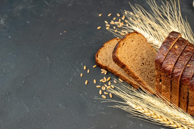 Kostenloses Foto vorderansicht von schwarzbrotscheiben spikes knoblauch auf schwarzem hintergrund mit freiem platz