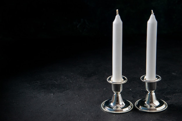 Vorderansicht von weißen langen Kerzen auf dunklem Boden Krieg bösen Tod Beerdigung Licht