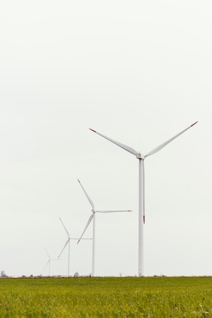 Vorderansicht von Windkraftanlagen im Feld mit Kopierraum