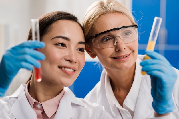 Kostenloses Foto vorderansicht von wissenschaftlerinnen, die substanz im labor analysieren