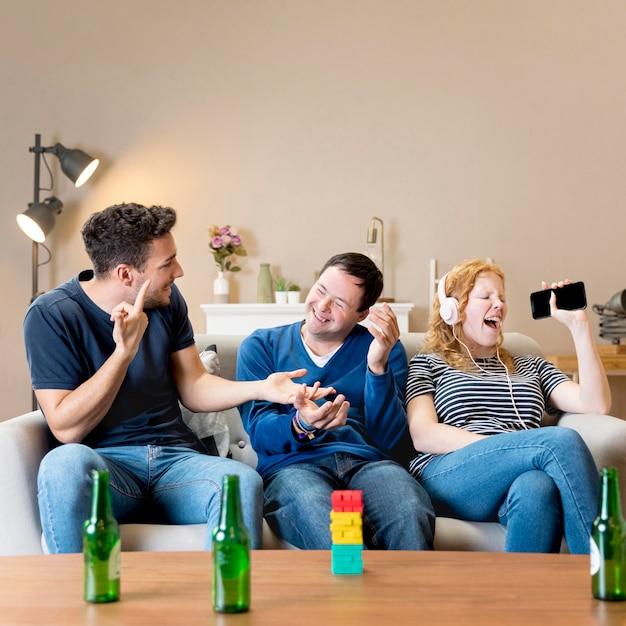 Kostenloses Foto vorderansicht von zwei männern, die über das singen der frau lachen