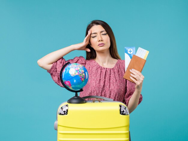 Vorderansicht weiblich in der Reise, die Brieftasche mit Tickets auf dem blauen Hintergrund Seereise Frau Reise Urlaub Reise hält