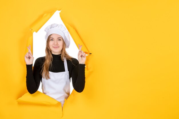 Vorderansicht weibliche Köchin lächelt und hofft auf gelbe Sonnenfarbe Papier Essen Job Foto Küche Emotion