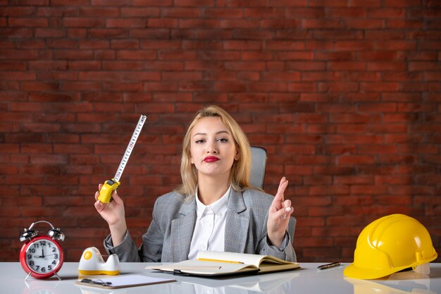 Vorderansicht weiblicher Ingenieur, der hinter ihrem Arbeitsplatz sitzt