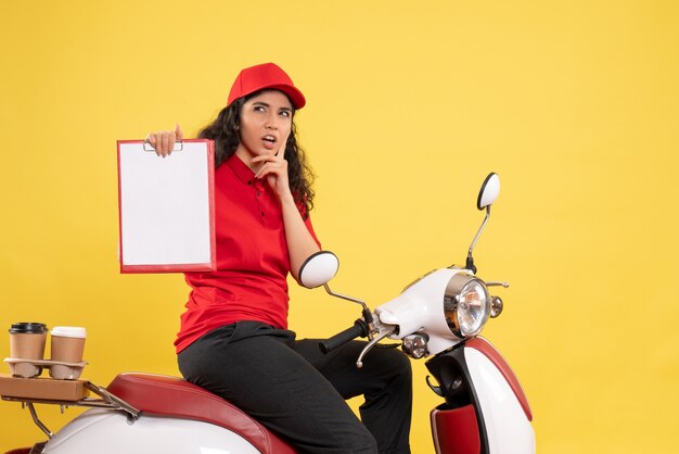 Vorderansicht weiblicher Kurier auf Fahrrad für Kaffeelieferung auf gelbem Hintergrund Lieferung einheitlicher Job Arbeiter Service Arbeit Frau Essen