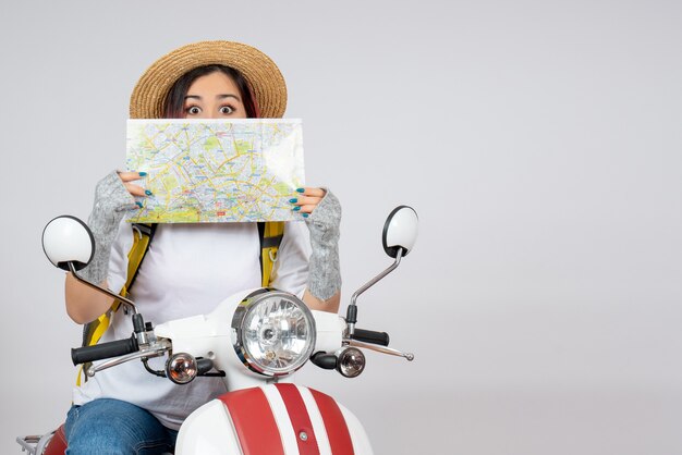 Vorderansicht weiblicher Tourist, der auf Motorrad mit weißer Wand der Karte sitzt