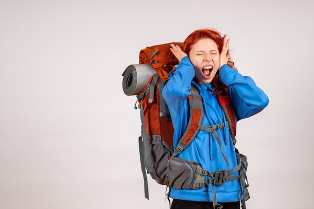 Vorderansicht weiblicher Tourist, der in Bergtour mit Rucksack geht, der ihre Ohren bedeckt