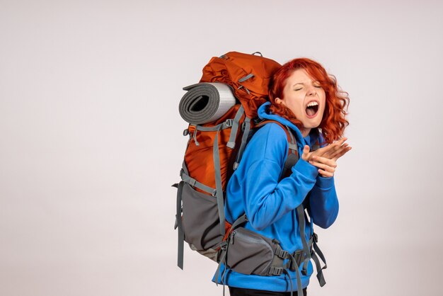 Vorderansicht weiblicher Tourist, der in Bergtour mit Rucksack mit verletztem Arm geht