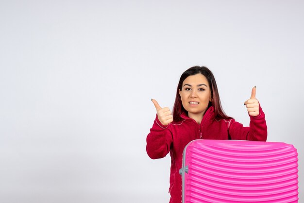 Vorderansicht weiblicher Tourist mit rosa Tasche an einer weißen Wand