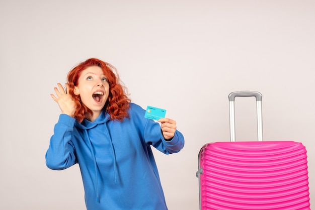 Vorderansicht weiblicher Tourist mit rosa Tasche und Haltebankkarte
