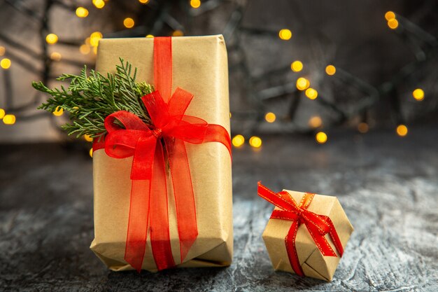 Vorderansicht Weihnachtsgeschenk mit rotem Band auf dunklem Hintergrund Weihnachtslichter gebunden