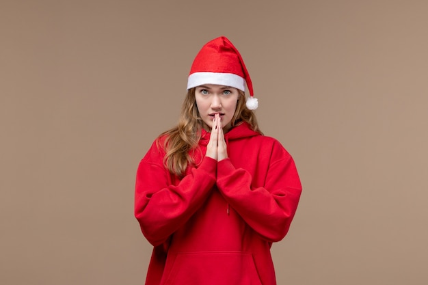 Vorderansicht-Weihnachtsmädchen mit nervösem Ausdruck auf braunem Raum