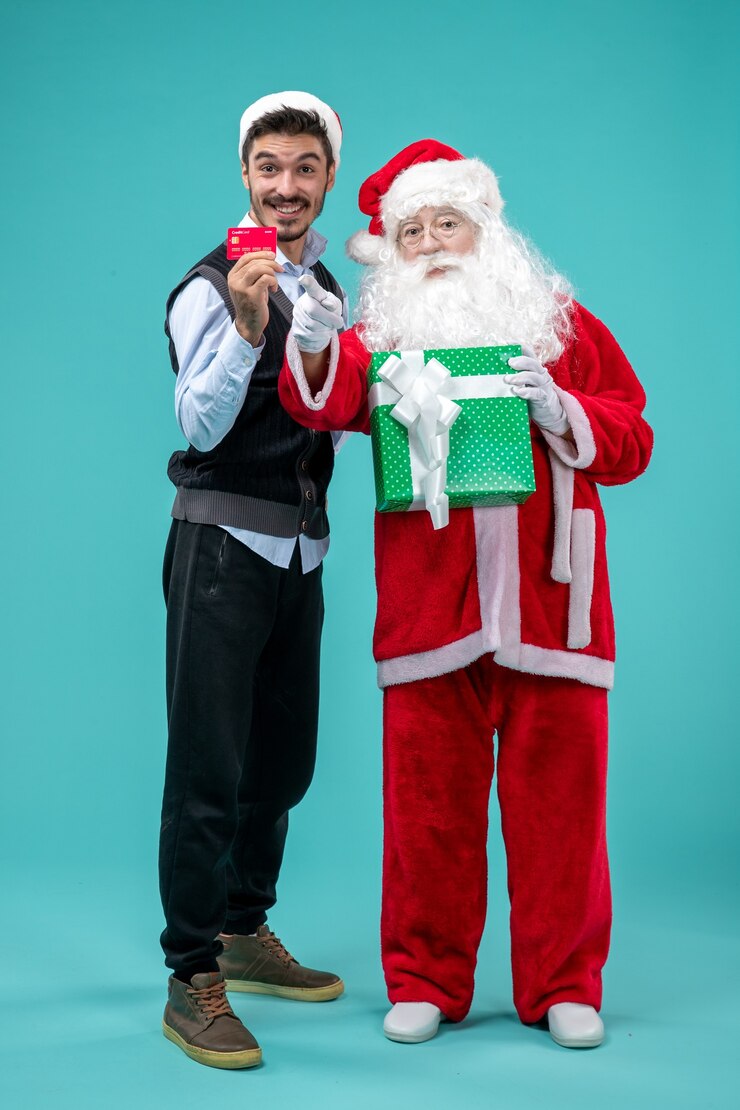 Kostenlose Foto vorderansicht weihnachtsmann, der geschenk mit jungem mann hält