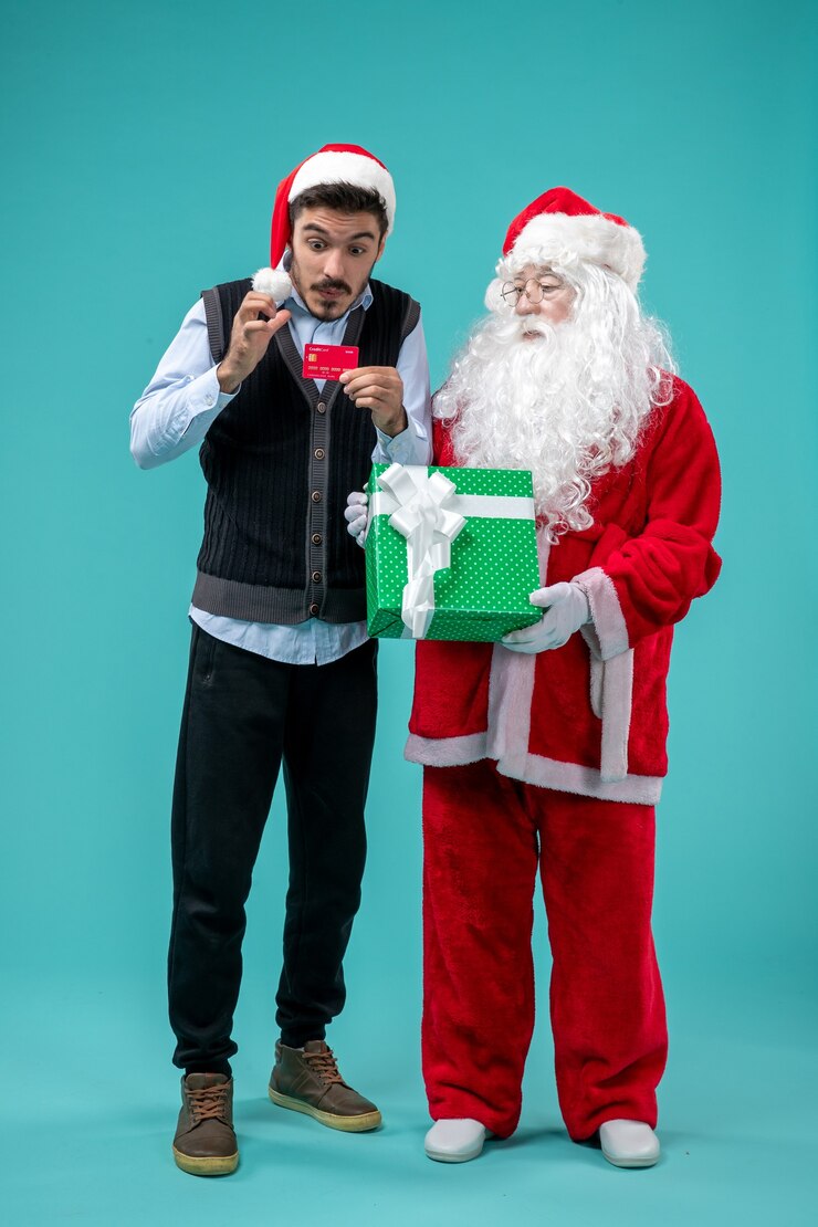 Kostenlose Foto vorderansicht weihnachtsmann, der geschenk mit jungem mann hält