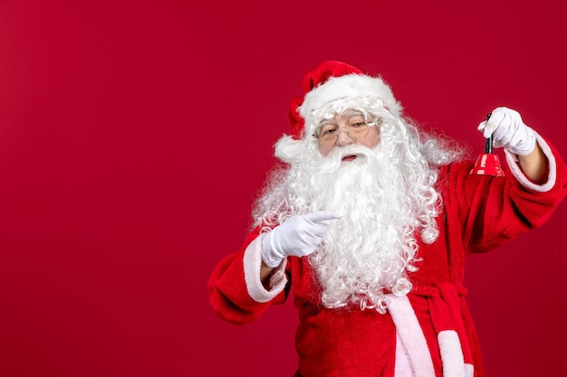 Vorderansicht Weihnachtsmann hält kleine Glocke auf dem roten Emotion Weihnachten Neujahr Geschenk Urlaub