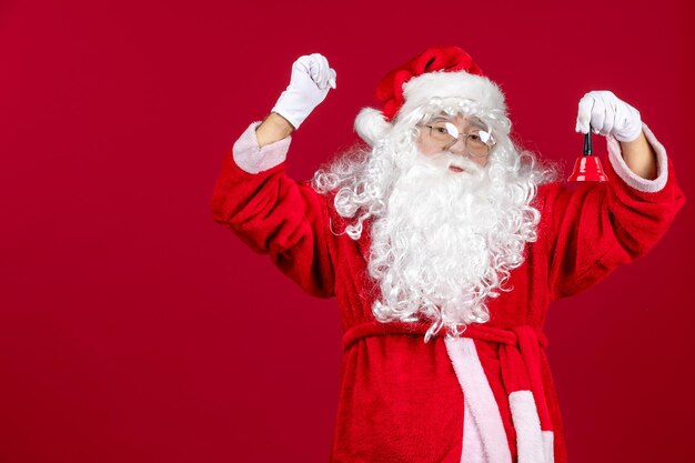 Vorderansicht Weihnachtsmann hält kleine Glocke auf dem roten Weihnachtsgeschenk Emotion Urlaub
